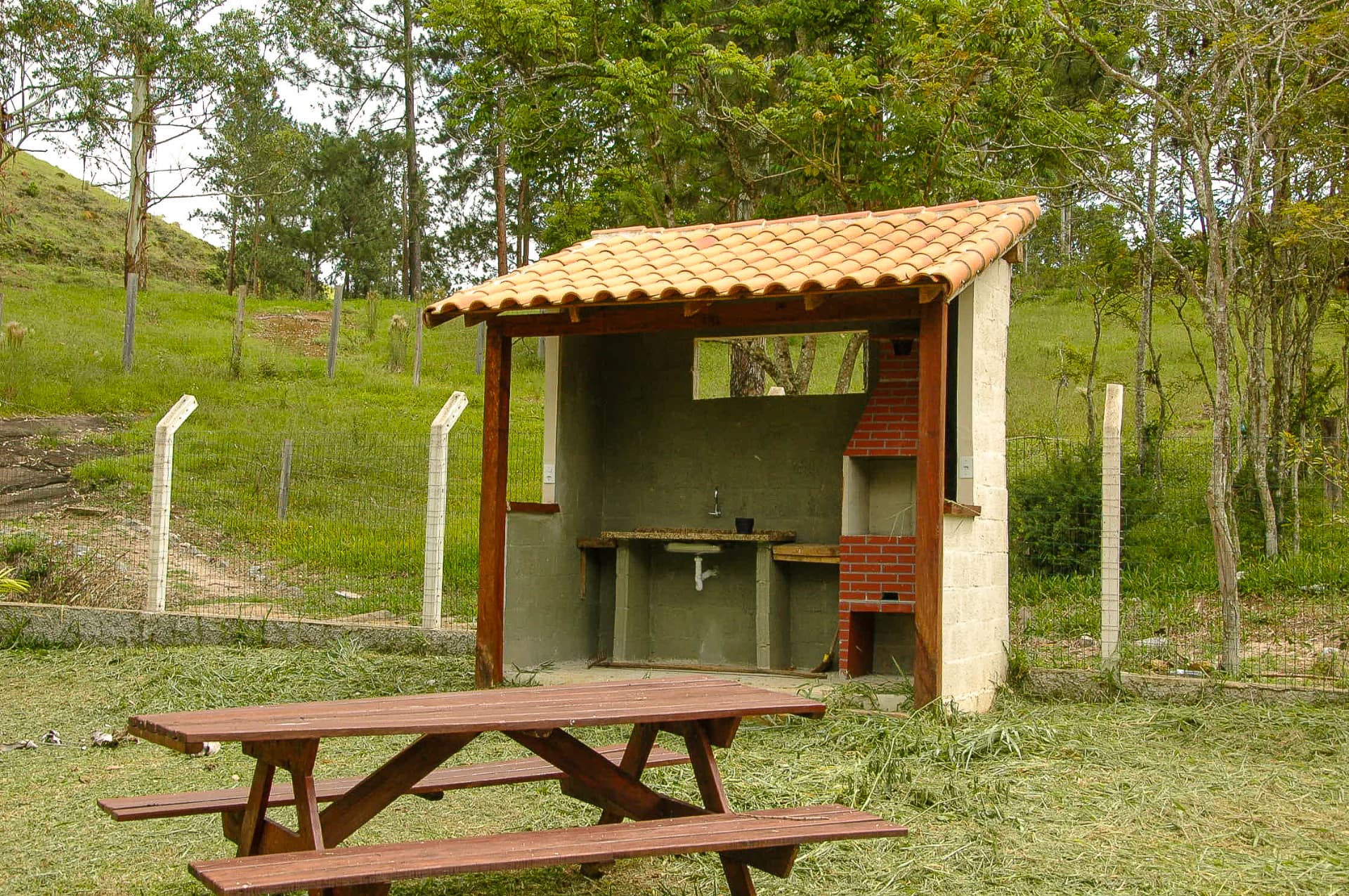 Churrasqueira coberta com mesa de piquenique na área de lazer